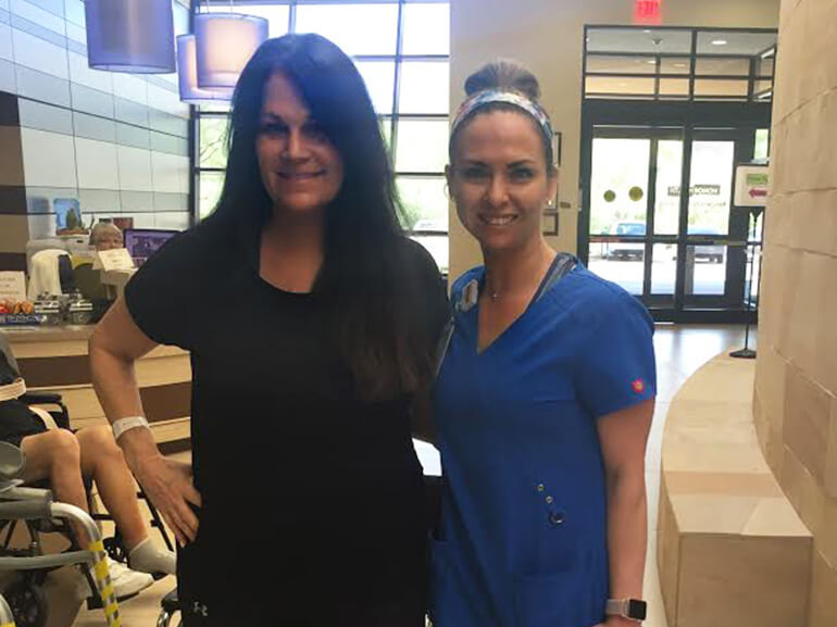 Shannon standing with one of her therapists in hospital lobby.